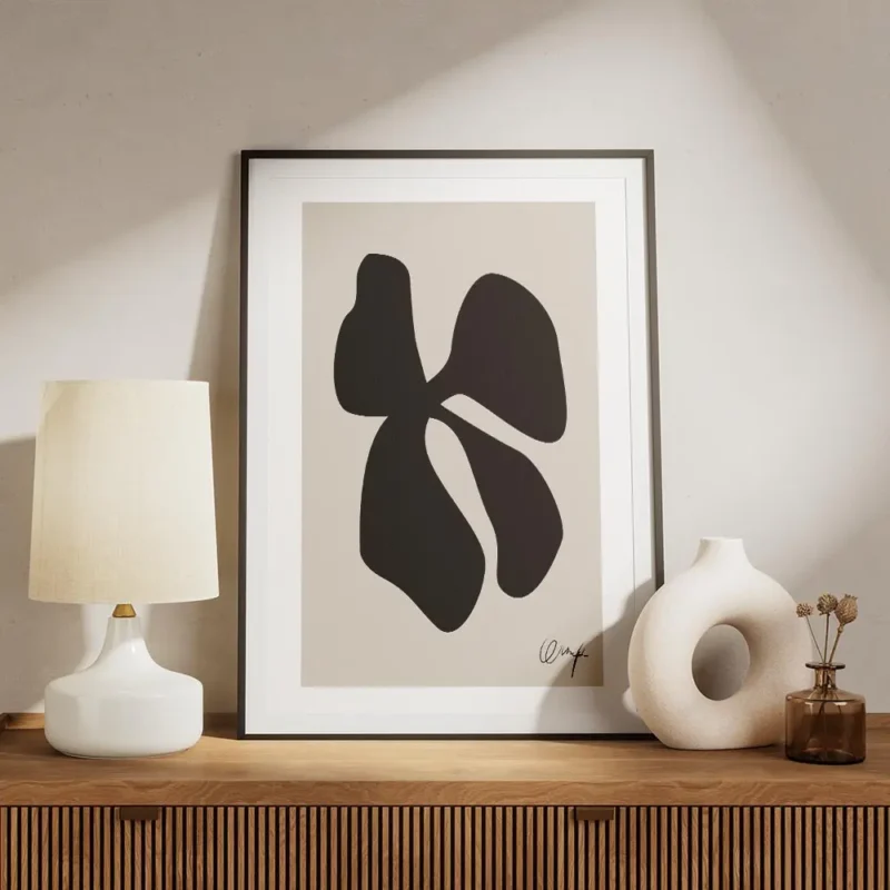 affiche avec un trefle abstrait noir sur fond beige typographie noire en bas a d meuble.webp