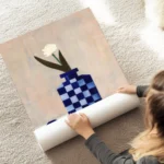 affiche avec un vase a carreaux bleu et blanc et une fleur blanche sur une surfa au sol.webp
