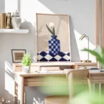 affiche avec un vase a carreaux bleu et blanc et une fleur blanche sur une surfa bureau.webp