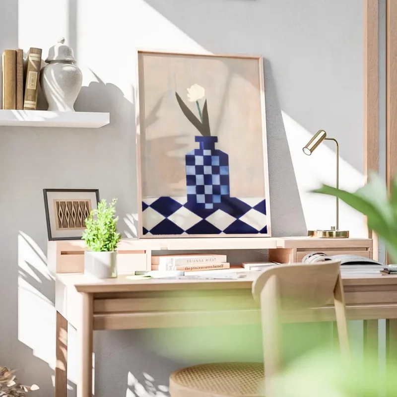 affiche avec un vase a carreaux bleu et blanc et une fleur blanche sur une surfa bureau.webp