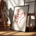 affiche avec un visage abstrait rouge bordeaux et une main sur fond beige clair encadre.webp