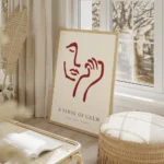 affiche avec un visage abstrait rouge bordeaux et une main sur fond beige clair salon beige.webp