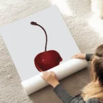 affiche avec une cerise rouge vif recouverte de sirop brillant sur fond gris cla au sol.webp