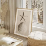 affiche avec une etoile de mer et un coquillage blanc sur du sable pale salon beige.webp
