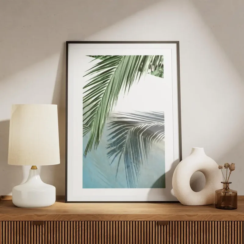 affiche avec une feuille de palmier verte et son reflet dans leau turquoise dune meuble.webp