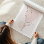 affiche avec une feuille rose en line art sur fond rose texture avec deux cercle en rouleau.webp