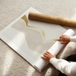 affiche avec une forme abstraite incurvee doree et beige sur fond gris clair enroule.webp