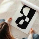 affiche avec une forme abstraite noire et blanche sur fond beige en rouleau.webp