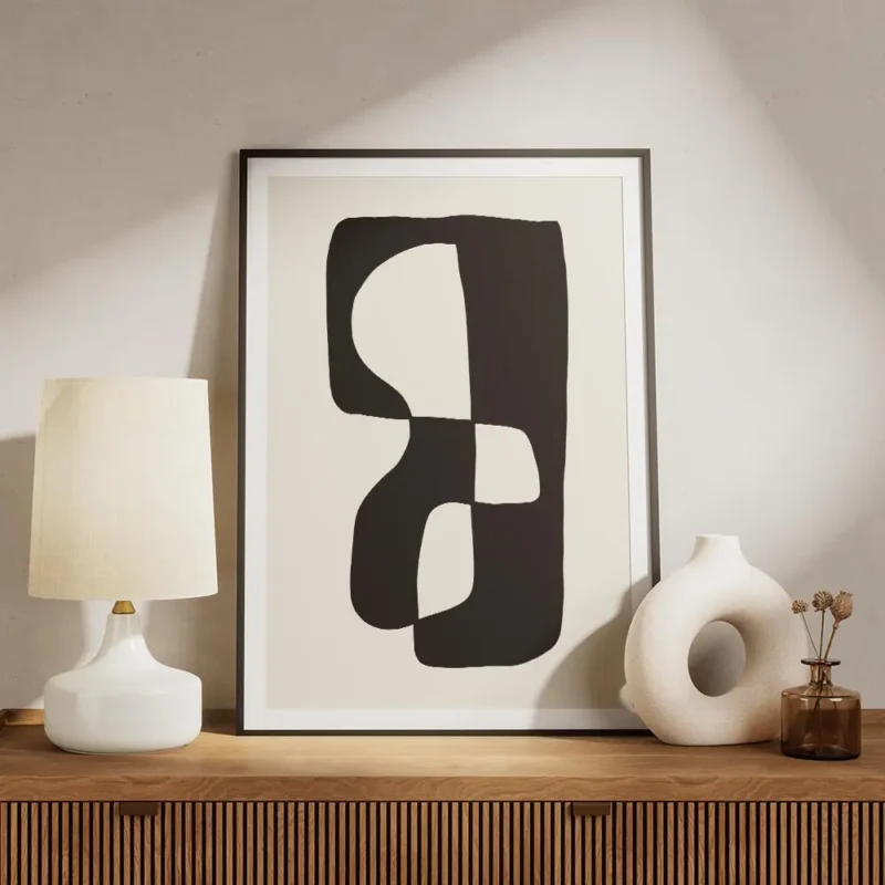 affiche avec une forme abstraite noire et blanche sur fond beige meuble.webp