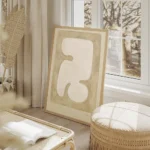 affiche avec une forme organique blanche aux courbes douces encadree par des ton salon beige.webp