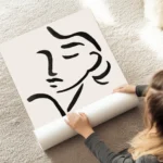 affiche avec une illustration de line art dun visage feminin abstrait en noir su au sol.webp