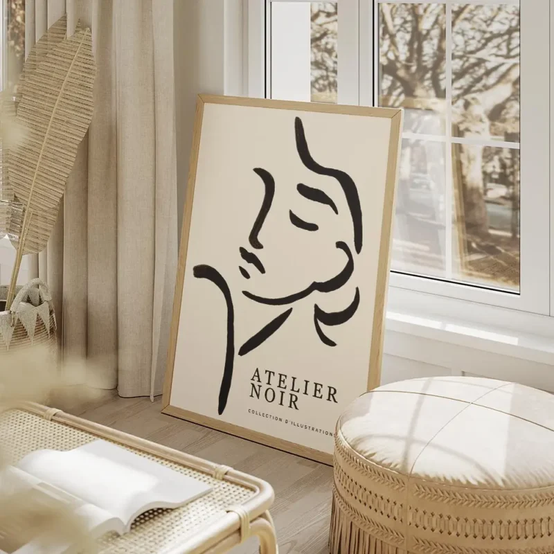 affiche avec une illustration de line art dun visage feminin abstrait en noir su salon beige.webp