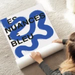 affiche avec une ligne bleue sinueuse et du texte noir style moderne au sol.webp