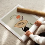 affiche avec une main noire en equilibre sur une papaye une figue une orange et enroule.webp