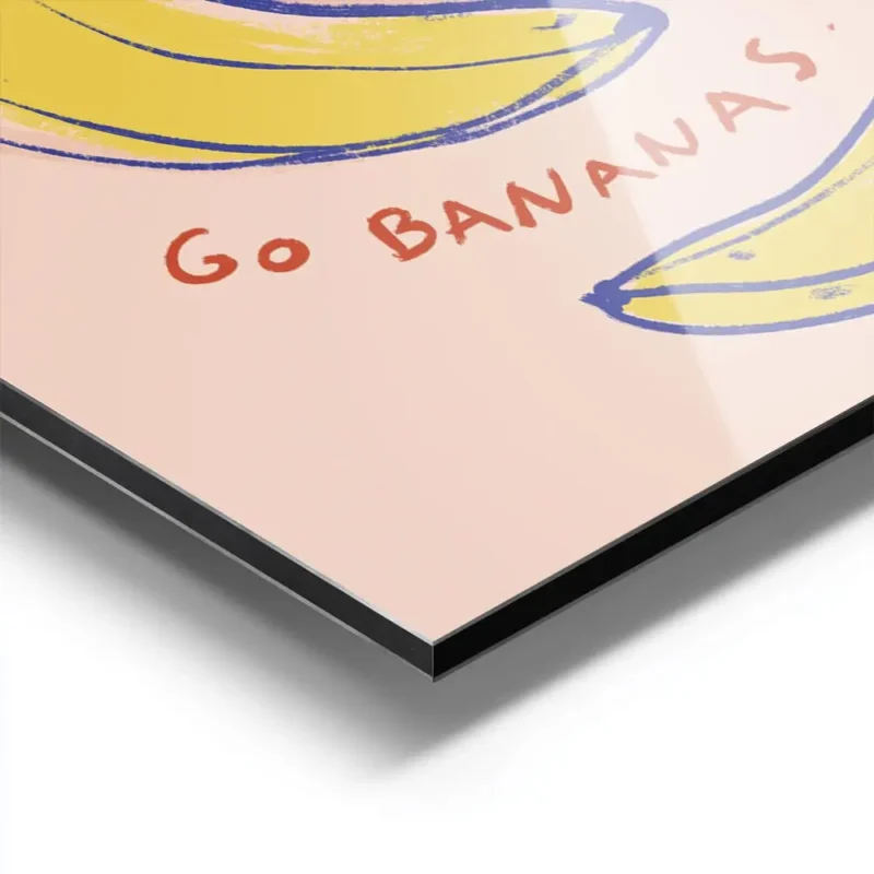 affiche avec une main orange tenant des bananes jaunes et bleues sur fond rose p aluminium.webp