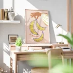 affiche avec une main orange tenant des bananes jaunes et bleues sur fond rose p bureau.webp