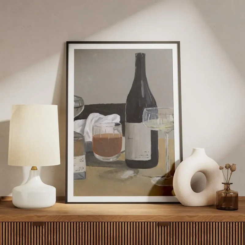 affiche avec une nature morte de bouteille de vin verre a pied et verre a whisky meuble.webp