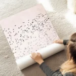 affiche avec une nuee doiseaux noirs en vol sur un fond rose texture illustratio au sol.webp