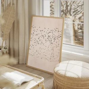 affiche avec une nuee doiseaux noirs en vol sur un fond rose texture illustratio salon beige.webp