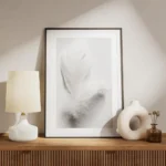 affiche avec une plume blanche duveteuse et legere posee sur un fond blanc pour meuble.webp