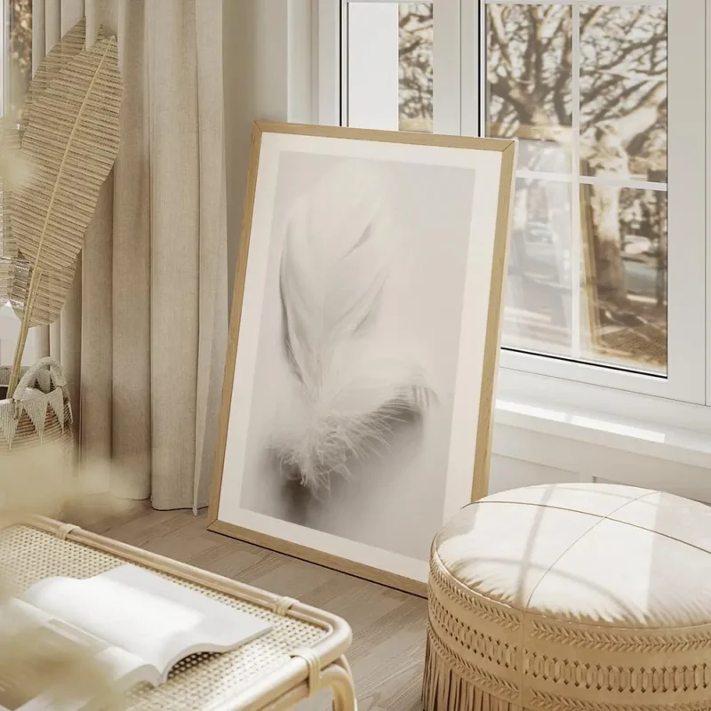 affiche avec une plume blanche duveteuse et legere posee sur un fond blanc pour salon beige.webp