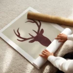 affiche avec une silhouette de cerf rouge sur fond beige typographie aquarelle f enroule.webp