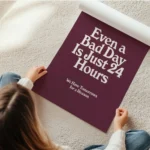 affiche bad day avec typographie blanche sur fond bordeaux presentant une citati en rouleau.webp