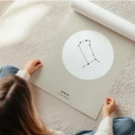 affiche beige avec illustration astrologique des gemeaux en noir dans un cercle en rouleau.webp