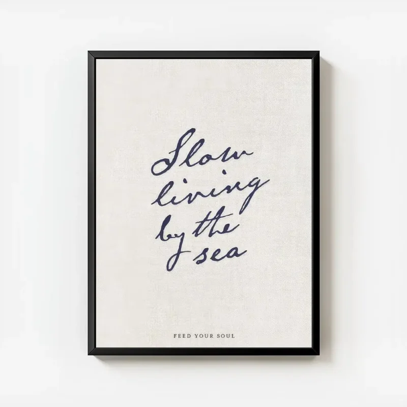 affiche beige avec le texte manuscrit slow living by the sea en bleu fonce et fe avec cadre.webp