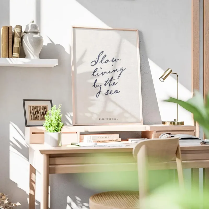 affiche beige avec le texte manuscrit slow living by the sea en bleu fonce et fe bureau.webp