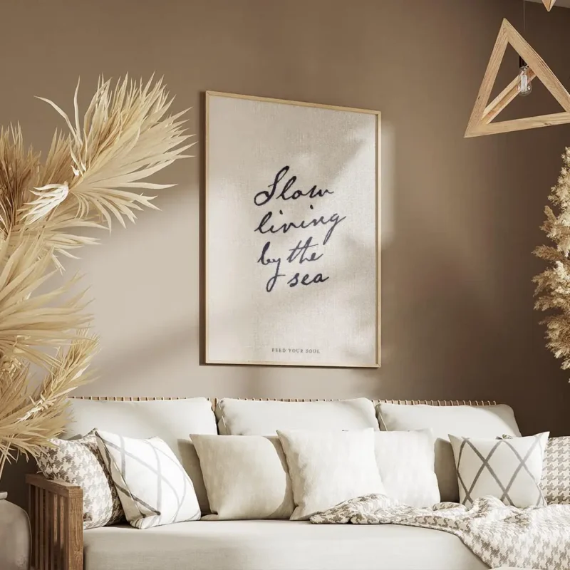 affiche beige avec le texte manuscrit slow living by the sea en bleu fonce et fe salon.webp