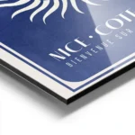 affiche bleu fonce avec un soleil blanc eclatant et du texte vacances nice cote aluminium.webp