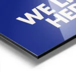 affiche bleue avec le texte embrace the chaos et we live here en blanc casse sty aluminium.webp