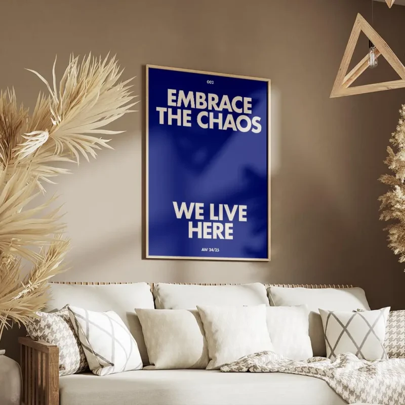 affiche bleue avec le texte embrace the chaos et we live here en blanc casse sty salon.webp