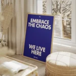 affiche bleue avec le texte embrace the chaos et we live here en blanc casse sty salon beige.webp