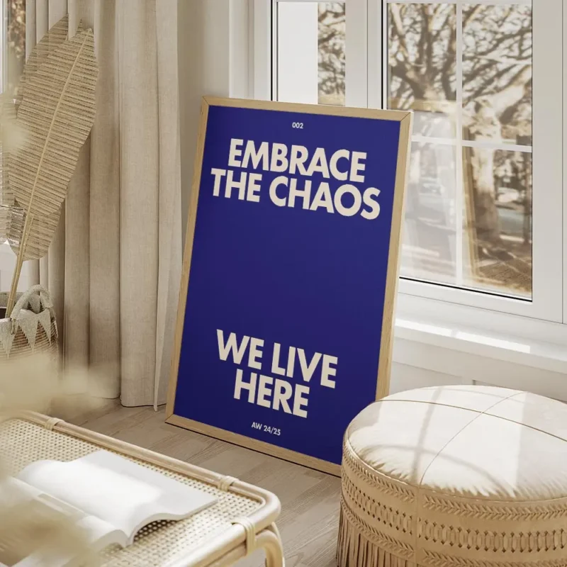 affiche bleue avec le texte embrace the chaos et we live here en blanc casse sty salon beige.webp