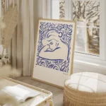 affiche bleue illustrant une femme en reverie entouree de feuillages bleus avec salon beige.webp