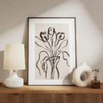 affiche botanique avec des fleurs noires et des feuilles dans un vase noir sur f meuble.webp
