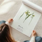 affiche botanique avec la lettre m formee de feuilles vertes et de fleurs jaunes en rouleau.webp