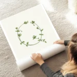 affiche botanique avec la lettre q formee de feuilles vertes et de fleurs blanch au sol.webp