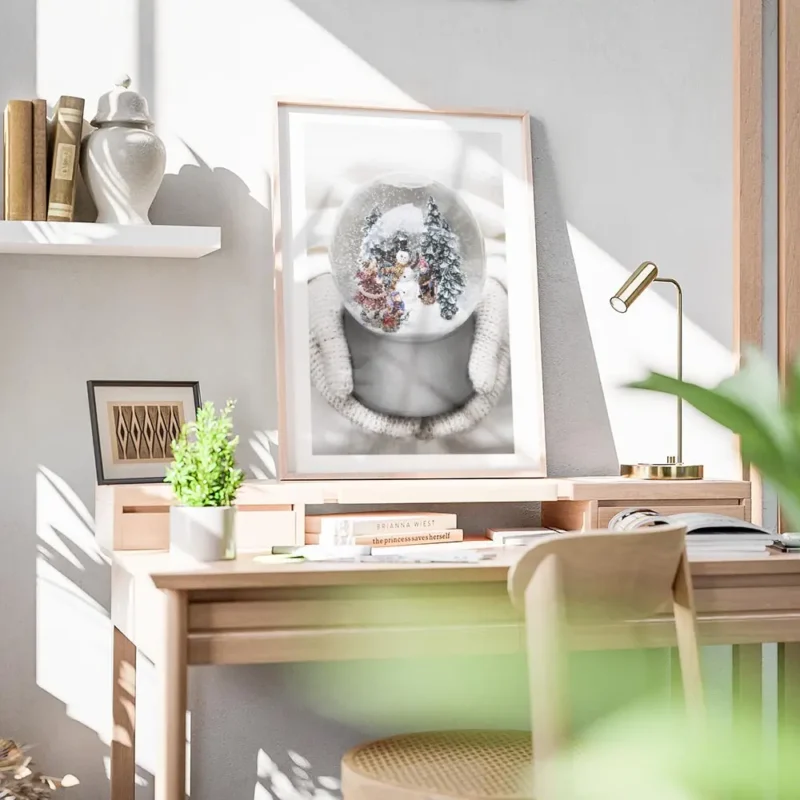affiche boule a neige avec bonhomme de neige sapins et enfants tenue par des mai bureau.webp