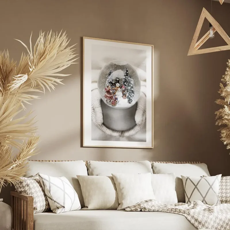 affiche boule a neige avec bonhomme de neige sapins et enfants tenue par des mai salon.webp