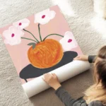 affiche britty flynn vase orange sur table noire avec des fleurs blanches et typ au sol.webp