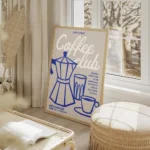 affiche coffee club sur fond gris avec une cafetiere bleue une tasse et un verre salon beige.webp