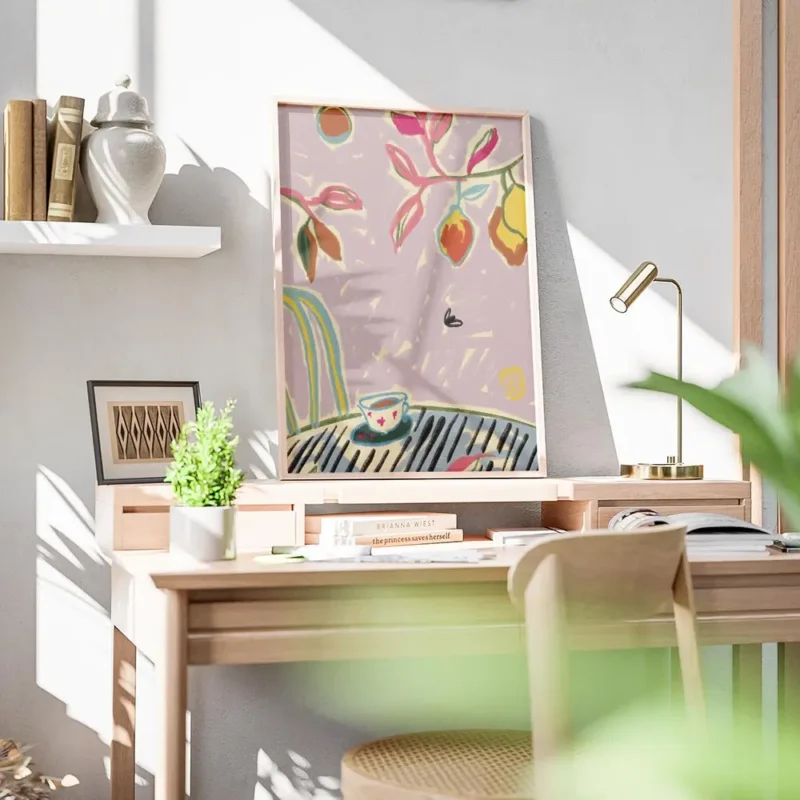 affiche coloree avec tasse de cafe sur une table feuillage vert et rose et fruit bureau.webp