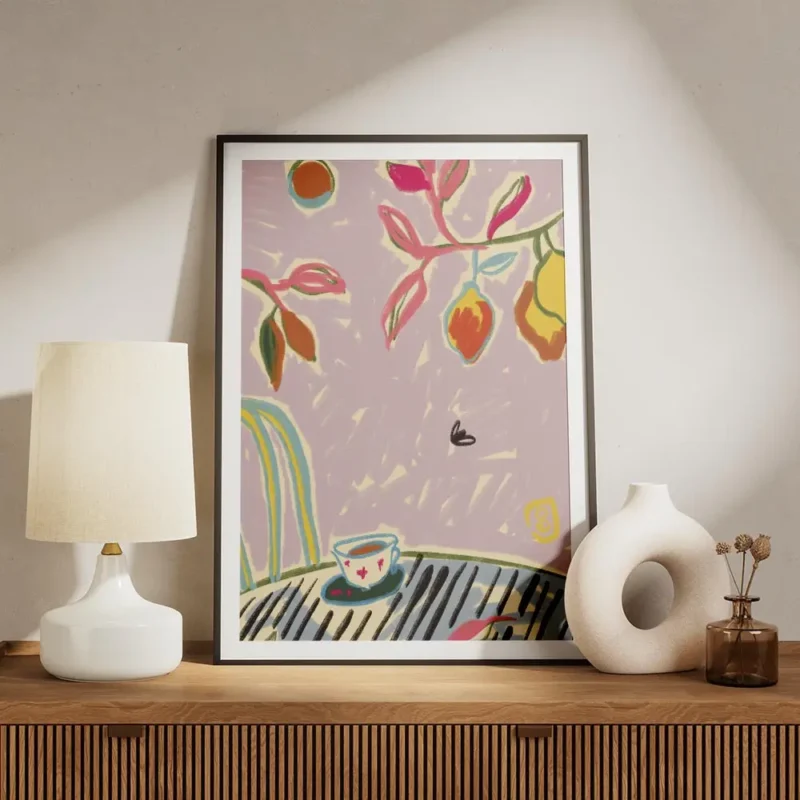 affiche coloree avec tasse de cafe sur une table feuillage vert et rose et fruit meuble.webp