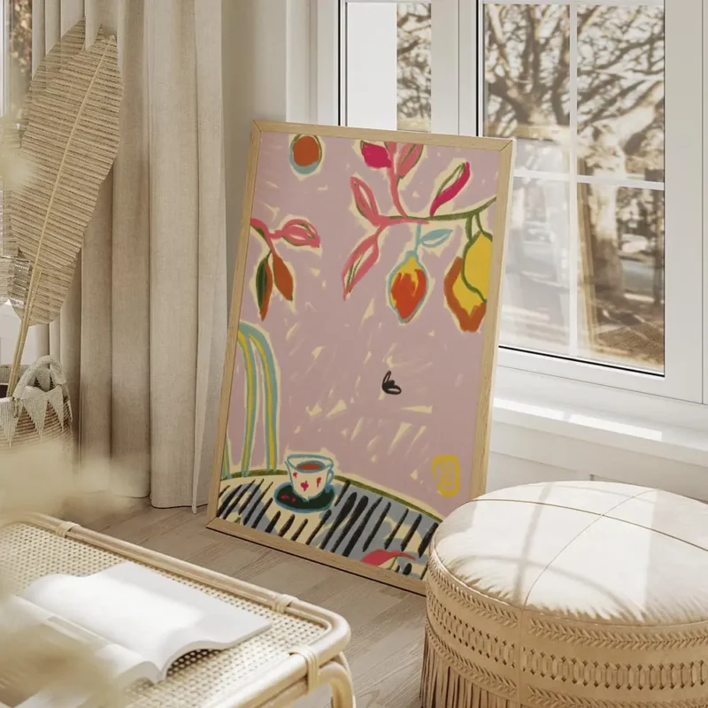 affiche coloree avec tasse de cafe sur une table feuillage vert et rose et fruit salon beige.webp