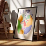 affiche coloree montrant deux visages abstraits sembrassant avec le mot embaasse encadre.webp