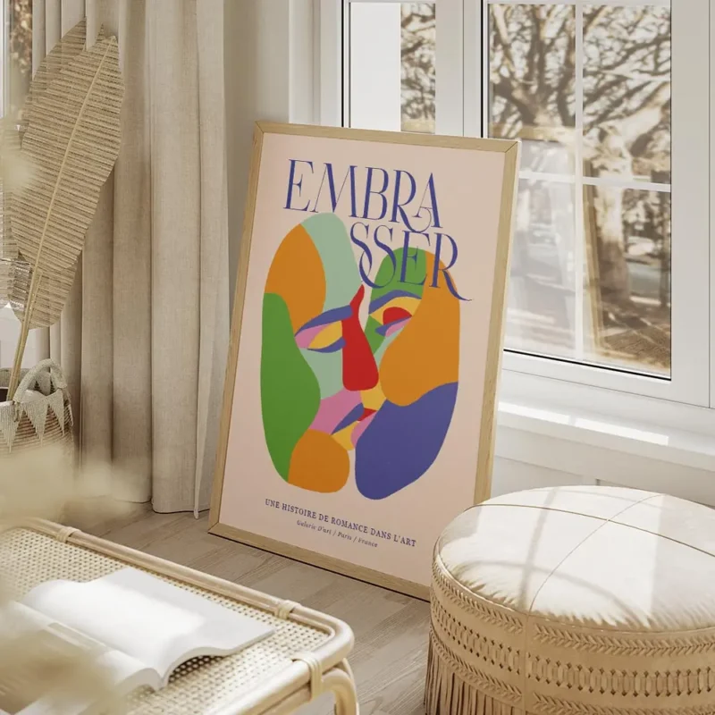 affiche coloree montrant deux visages abstraits sembrassant avec le mot embaasse salon beige.webp