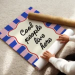 affiche cool people live here avec typographie noire sur forme creme sur fond a enroule.webp